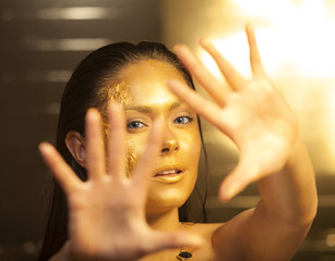 Woman with golden makeup and bodyart