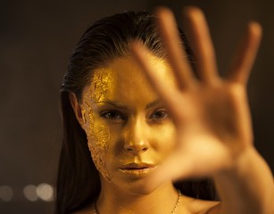 Woman with golden makeup and bodyart