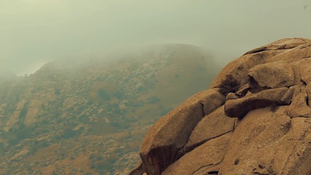 Amazing aerial view of desert and mountains covered with fog or mist on a cloudy day. 
