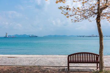 Fototapeta na wymiar Chair under the tree at seaside.