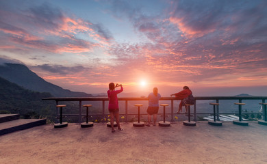 Fototapeta na wymiar Traveller relaxing on top of hill and enjoying sunrise over the