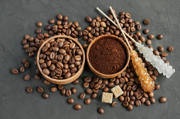 Coffee beans and ground coffee in a wooden bowl and cane sugar