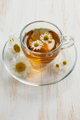 Healthy tea with honey and chamomile in glass cup