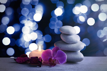 White spa stones with candle on blue festive background