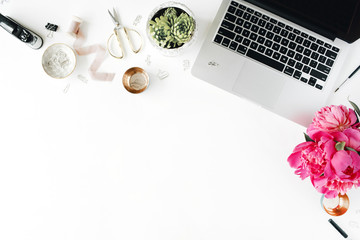Workplace with laptop, succulent, peonies, golden scissors, spool with beige ribbon, pencils and...