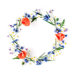 floral frame with red poppies, chamomile flowers, cornflowers and green branches. Flat lay, top view