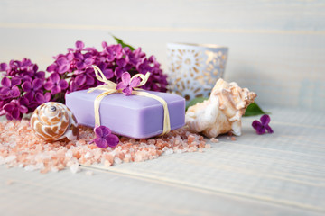 Obraz na płótnie Canvas Organic spa soaps with lilac flowers and sea salt on white wood table. Empty space for text.