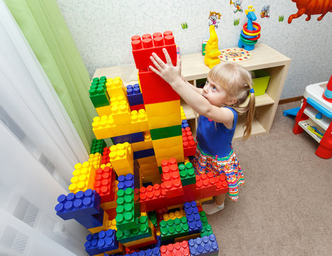Persistent little girl building big block tower in daycare