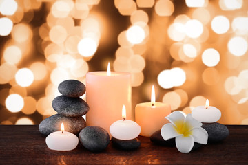 Fototapeta na wymiar Spa stones with burning candles and flowers on festive background