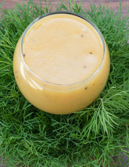 fruit smoothie of banana, orange, kiwi and tangerine in the glass