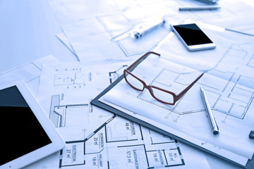 Blueprints and glasses on table, closeup