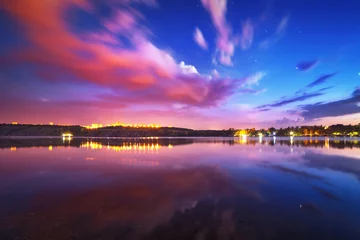 Papier Peint photo Nuit Colorful night landscape on the lake with blue sky and moving clouds reflected in water. Nature background