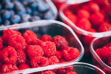 Baskets Full Of Raspberries And Blueberries On The Farmers Marke