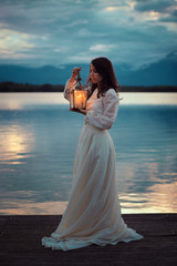 Vintage bride on lake pier with lantern © captblack76