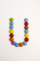 La lettera U formata da coloratissimi confetti di cioccolato.