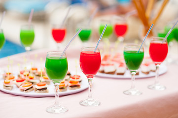 Colourful cocktails and snacks on the table near the pool