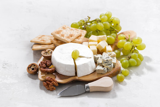 camembert, grapes and crackers on a white background