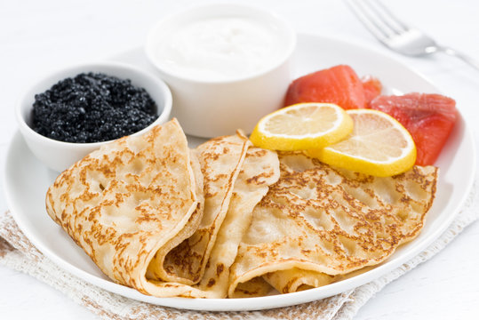 crepes with fish, sour cream and caviar, closeup