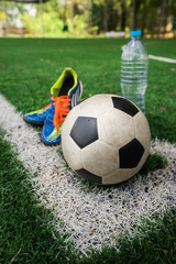 Football cleat and fresh water after the match on the field