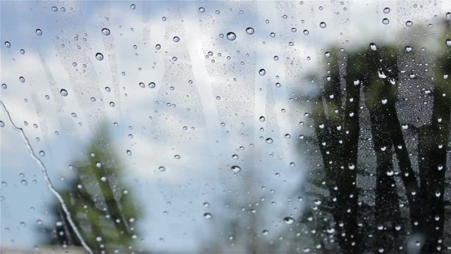 Water flows on car window/on front window of the car flowing water