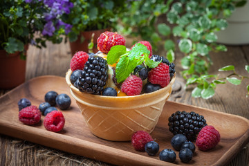 Tasty ice cream dessert with fruit in a waffle bowl.