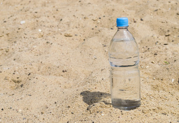 Plastic bottle with water on sand
