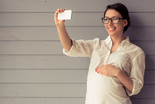Pregnant business woman with gadget