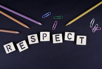Respect. Text from wooden letters on a black office desk.