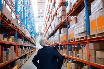 Warehouse manager turns back to the camera and looking up