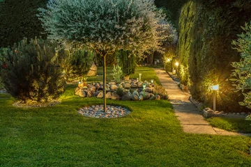 Foto auf Acrylglas Garten Garten beleuchtet von Lampen