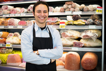 Smiling shopkeeper at work in a grocery store