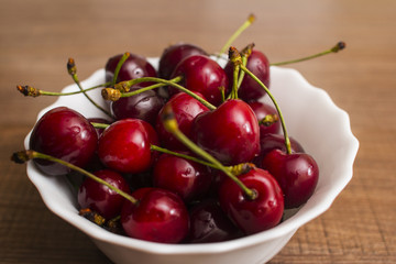 Cherries on wooden table with water drops macro background