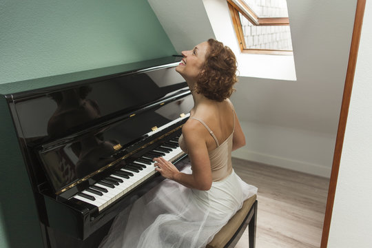 Ballerina performing and playing the piano in a house