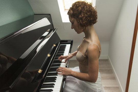 Ballerina performing and playing the piano in a house