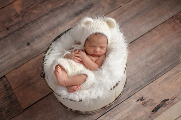 Obraz premium Newborn Girl Wearing a White Bear Hat