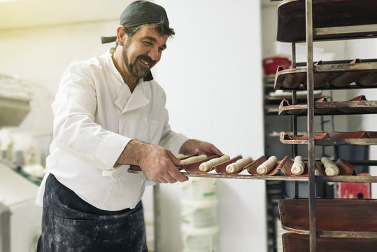 Baker kneading dough in a bakery.