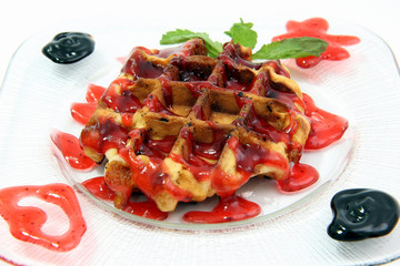 Belgian waffles with chocolate sauce isolated on white background