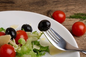 Fresh vegetables salad with tomatoes , olives , parmesan cheese