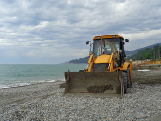 Трактор на побережье, подготовка пляжа к курортному сезону