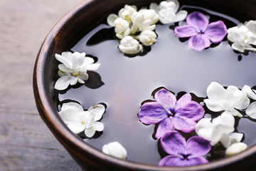 Fototapeta na wymiar Fresh lilac flowers in the bowl, closeup