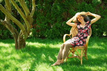 Smiling woman sitting on a chair in a garden