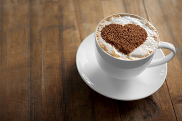 Cup of coffee with creative pattern on wooden table