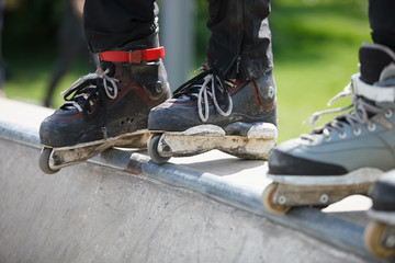 Aggressive inline rollerblader standing on ramp in skatepark