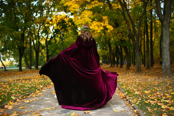 Beautiful girl with lantern in the scary autumn wood. Fantasy and Halloween image. Costumed woman...