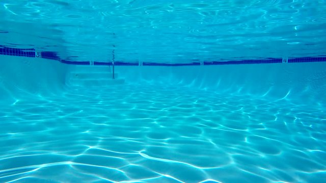 Underwater sunlight patterns in clean empty swimming pool.
