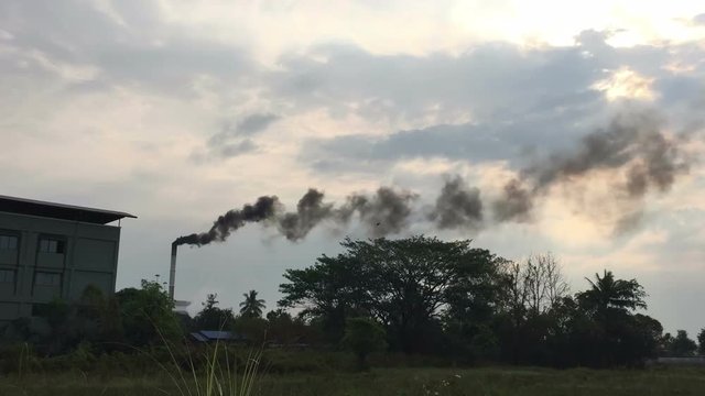 time lapse smoke from factory chimney over grey sky and clouds. Industrial pollution. Silhouette