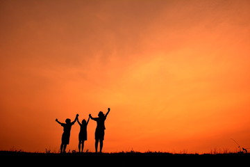 Silhouette women and children open hand in the sunset