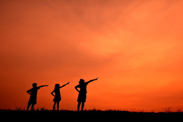 Fototapeta na wymiar Silhouette women and children open hand in the sunset