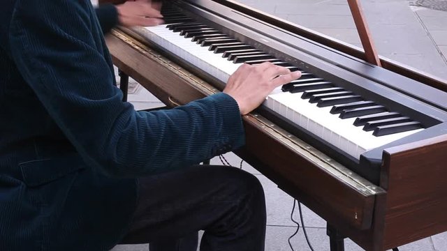 Man playing a pianoforte during a street concert