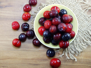 red plum on wooden background top view